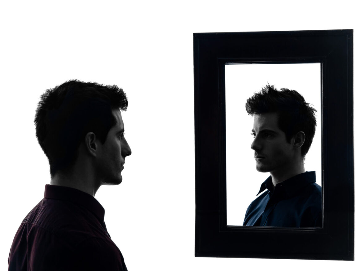 Man staring at his own reflection in mirror