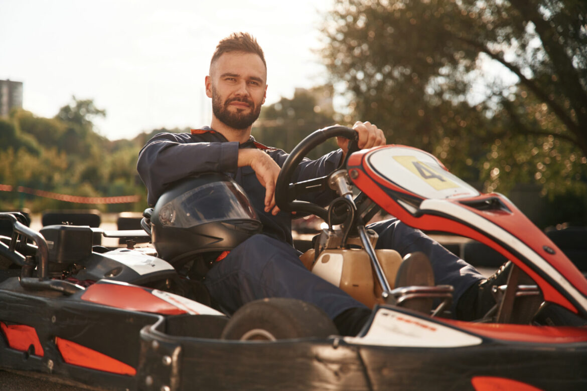 Trees and sunlight. Man is outdoors, kart racing conception